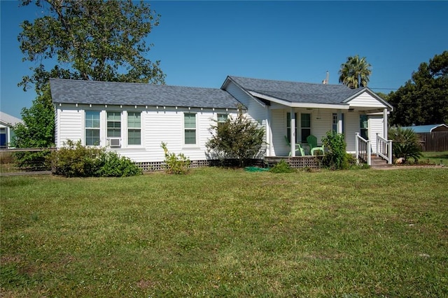 ranch-style home featuring a porch, a shingled roof, and a front lawn