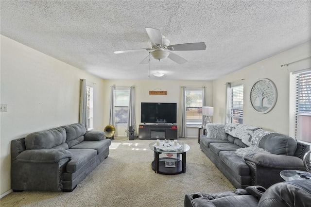 carpeted living area featuring baseboards, a textured ceiling, and a ceiling fan