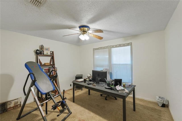 home office with visible vents, light carpet, baseboards, and a ceiling fan