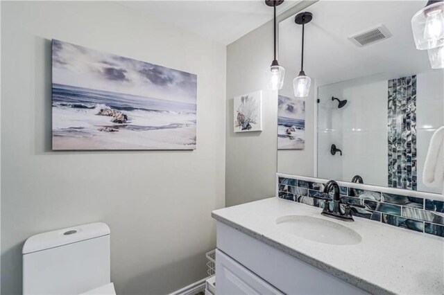 full bath with tasteful backsplash, vanity, a shower, toilet, and visible vents