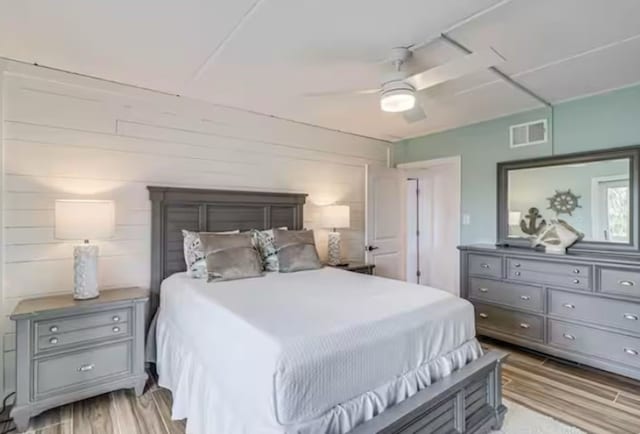 bedroom featuring light wood-style floors, visible vents, and ceiling fan