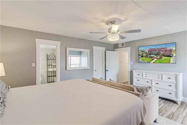 bedroom with light wood-style flooring, visible vents, baseboards, and ceiling fan