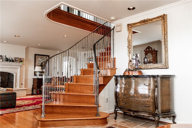 stairs featuring wood-type flooring and ornamental molding