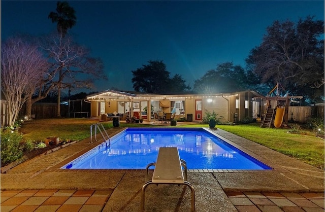 pool at night with a fenced in pool, a playground, fence, a yard, and a patio