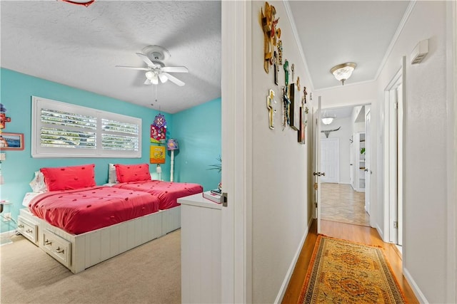 bedroom featuring baseboards, a textured ceiling, and a ceiling fan