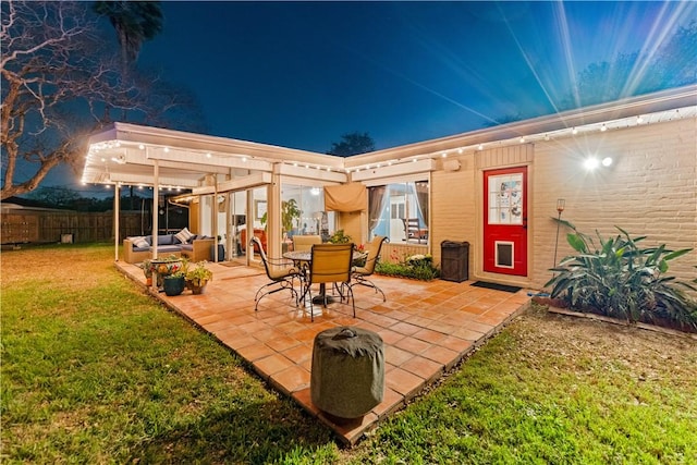 patio at twilight featuring a yard and fence