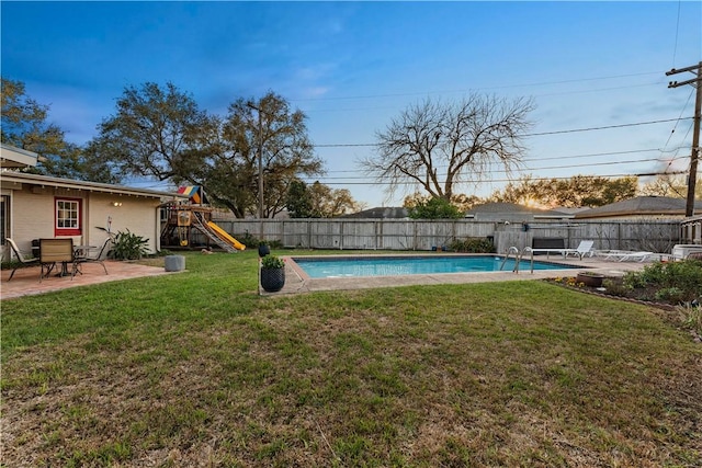 view of yard featuring a playground, a patio area, a fenced in pool, and a fenced backyard