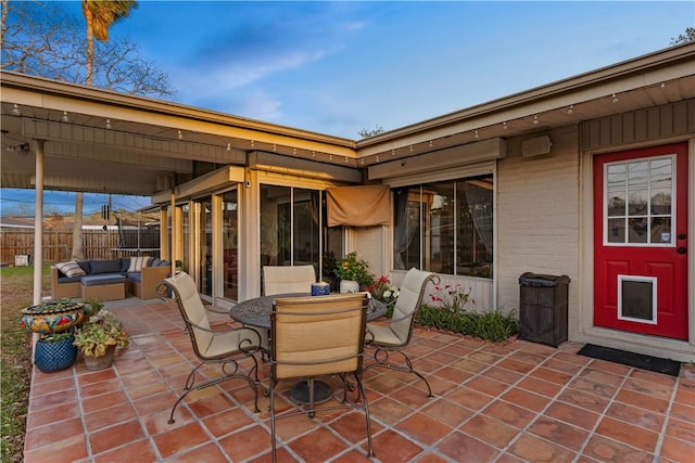 view of patio featuring an outdoor living space, outdoor dining area, fence, and a sunroom