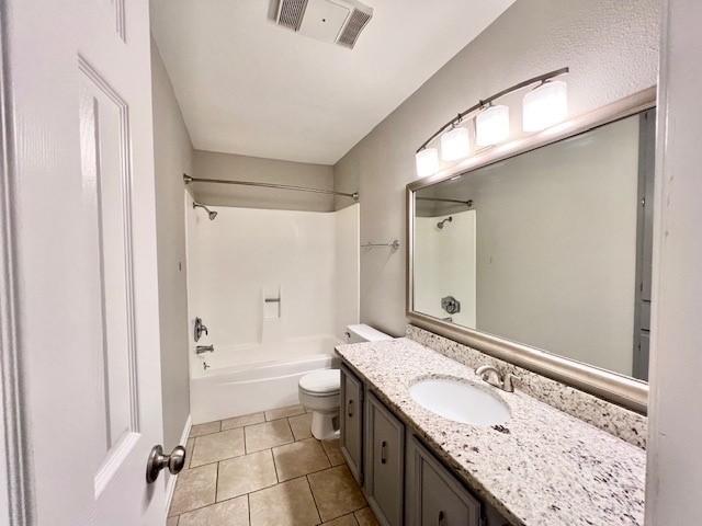 full bathroom with tile patterned flooring, vanity, tub / shower combination, and toilet