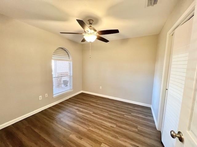 empty room featuring ceiling fan and dark hardwood / wood-style floors