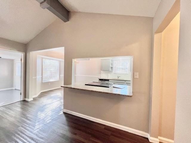 kitchen with kitchen peninsula, dark hardwood / wood-style flooring, lofted ceiling with beams, and sink