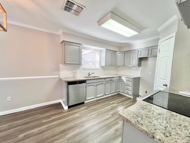 kitchen with dishwasher, sink, crown molding, light stone counters, and wood-type flooring