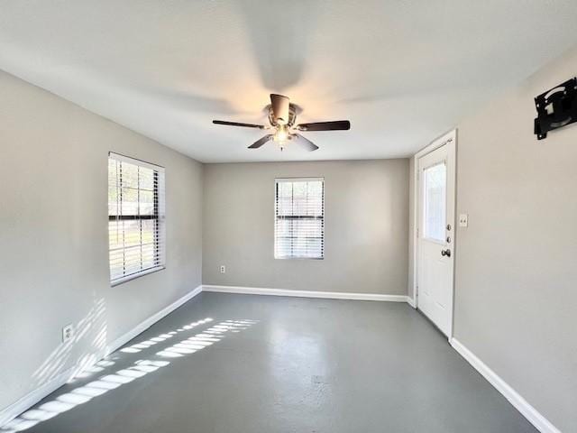 spare room featuring ceiling fan and a healthy amount of sunlight