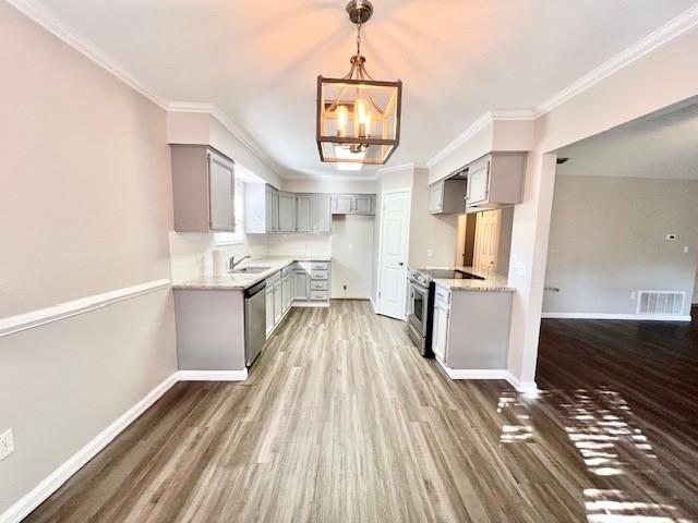 kitchen featuring gray cabinetry, sink, a notable chandelier, appliances with stainless steel finishes, and ornamental molding