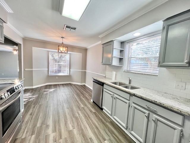 kitchen featuring sink, stainless steel dishwasher, backsplash, decorative light fixtures, and range