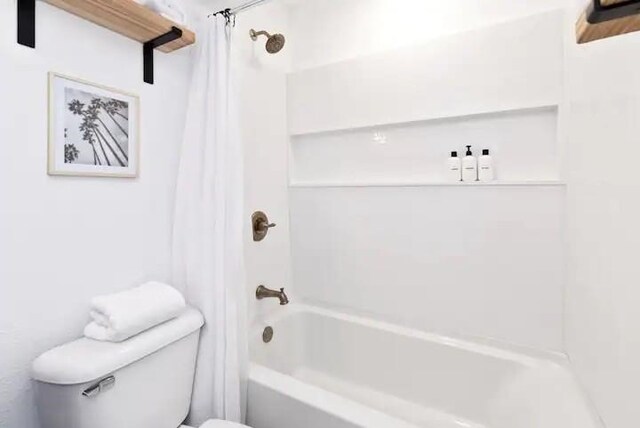 bathroom featuring shower / bath combination with curtain and toilet