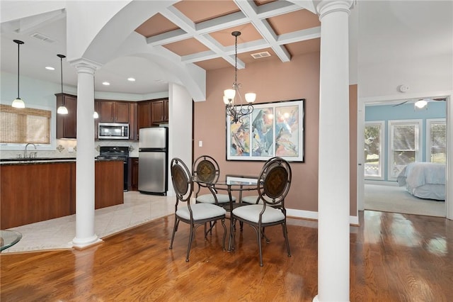 10 Old Cottage Beach Dr, Rockport, TX 78382 - dining space featuring decorative columns, coffered ceiling, light wood-style floors, beam ceiling, and arched walkways