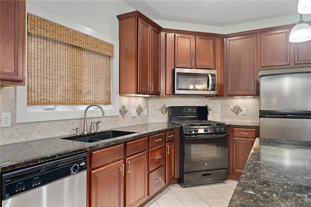 kitchen with stainless steel appliances, sink, tasteful backsplash, light tile patterned floors, and hanging light fixtures