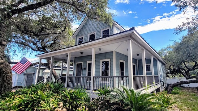 farmhouse featuring a garage and covered porch