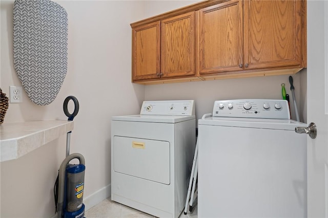 10 Old Cottage Beach Dr, Rockport, TX 78382 - laundry area featuring washing machine and clothes dryer, cabinet space, baseboards, and light tile patterned floors