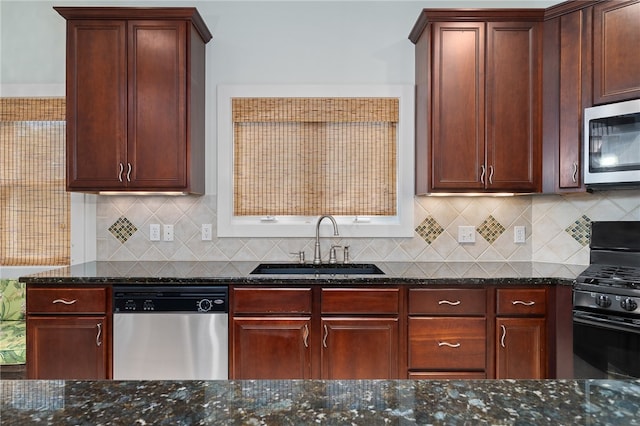 kitchen featuring dark stone countertops, sink, backsplash, and appliances with stainless steel finishes