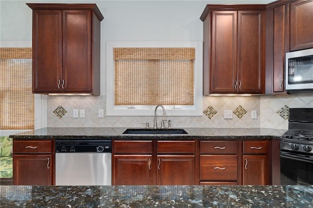 10 Old Cottage Beach Dr, Rockport, TX 78382 - kitchen featuring appliances with stainless steel finishes, a sink, dark stone counters, and reddish brown cabinets