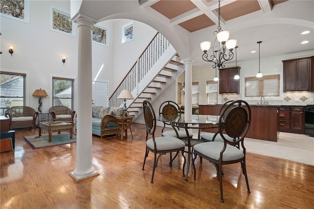 10 Old Cottage Beach Dr, Rockport, TX 78382 - dining area featuring ornate columns, a towering ceiling, beam ceiling, recessed lighting, and light wood-type flooring