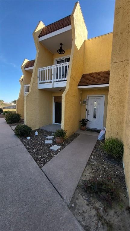 entrance to property with a balcony and stucco siding