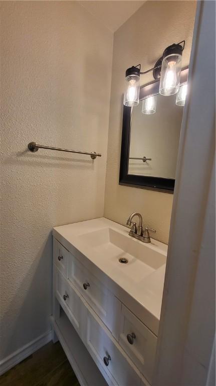 bathroom with a textured wall and vanity