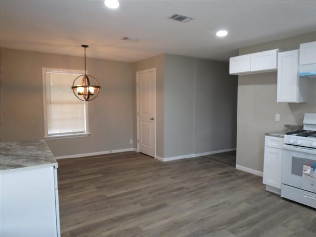 kitchen featuring an inviting chandelier, hanging light fixtures, dark wood-type flooring, white gas range, and white cabinets