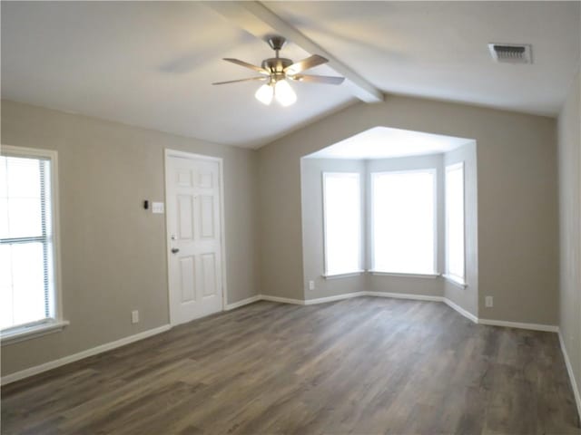 spare room with ceiling fan, lofted ceiling with beams, dark hardwood / wood-style flooring, and a wealth of natural light