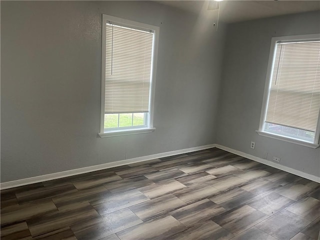 unfurnished room with dark wood-type flooring