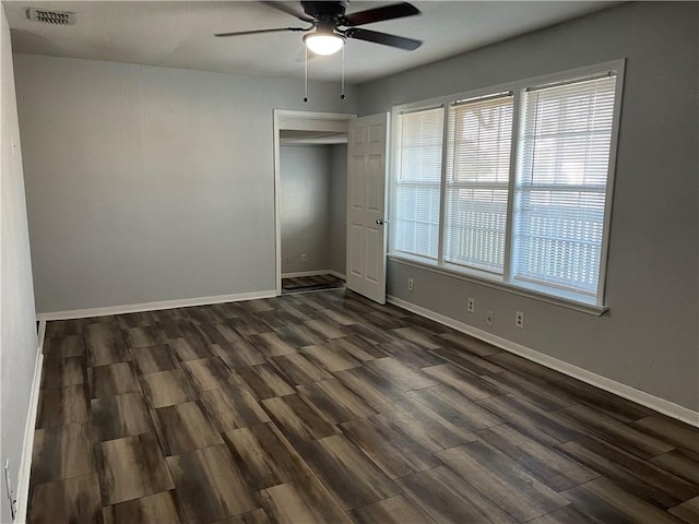 unfurnished bedroom featuring dark wood-type flooring, a closet, and ceiling fan