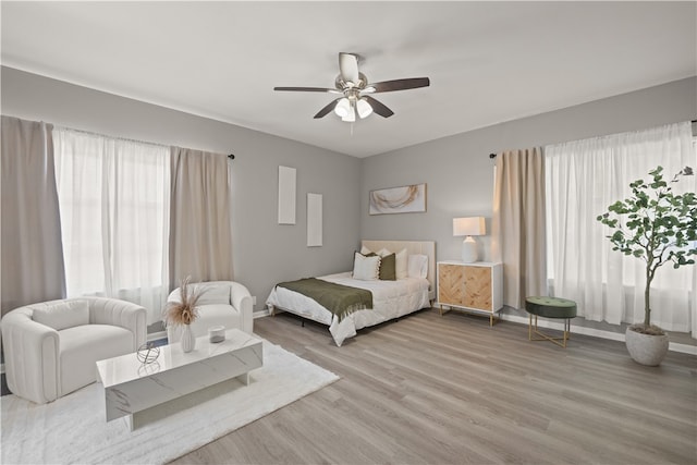 bedroom with light hardwood / wood-style floors and ceiling fan