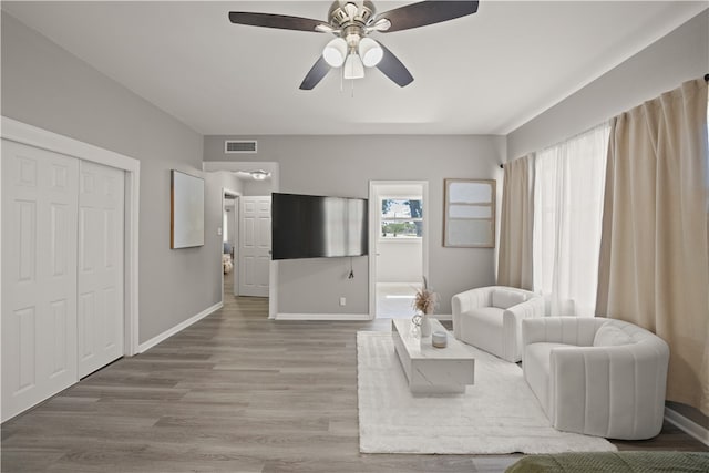 living room with wood-type flooring and ceiling fan