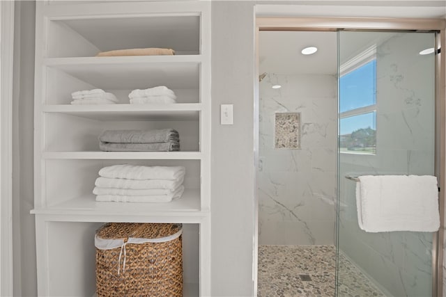 bathroom with built in shelves and an enclosed shower