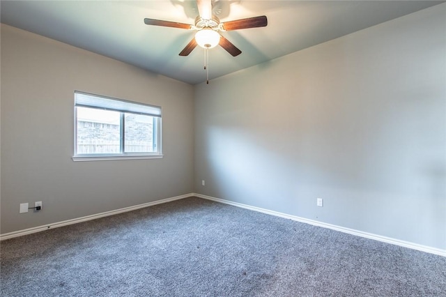 carpeted spare room featuring baseboards and ceiling fan