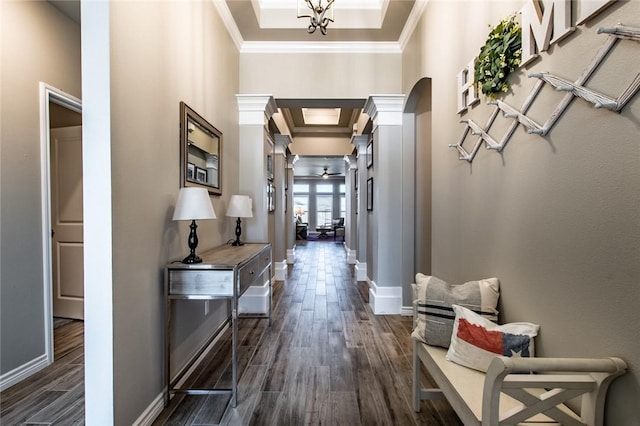 hall with decorative columns, baseboards, dark wood finished floors, and crown molding