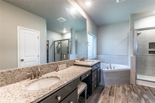 full bath with a sink, a garden tub, wood tiled floor, and a shower stall