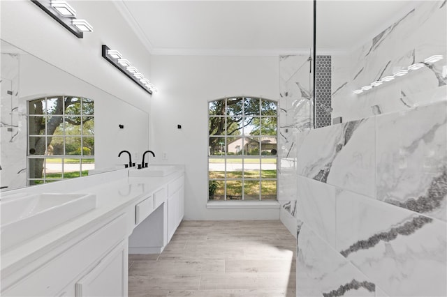 bathroom with vanity, plenty of natural light, hardwood / wood-style floors, and ornamental molding