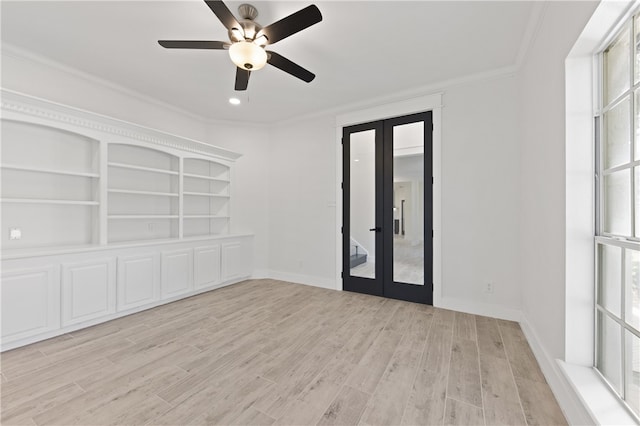 spare room with a wealth of natural light, french doors, light hardwood / wood-style floors, and crown molding