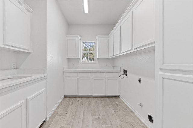 laundry room featuring cabinets, hookup for an electric dryer, and light wood-type flooring