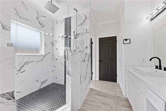 bathroom with wood-type flooring, crown molding, vanity, and a shower with shower door