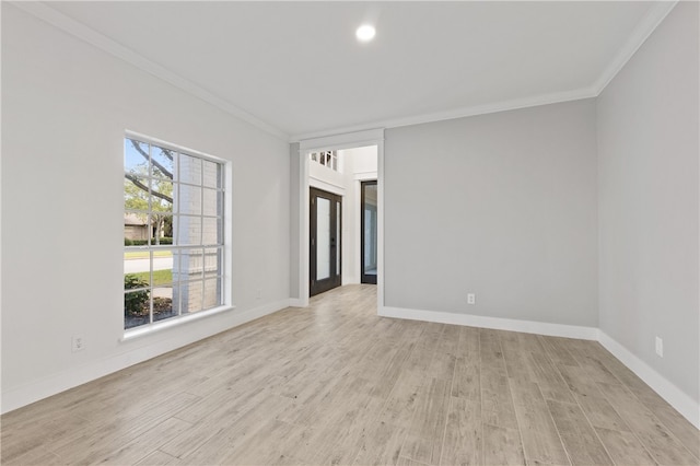 empty room featuring ornamental molding, light wood-type flooring, and french doors