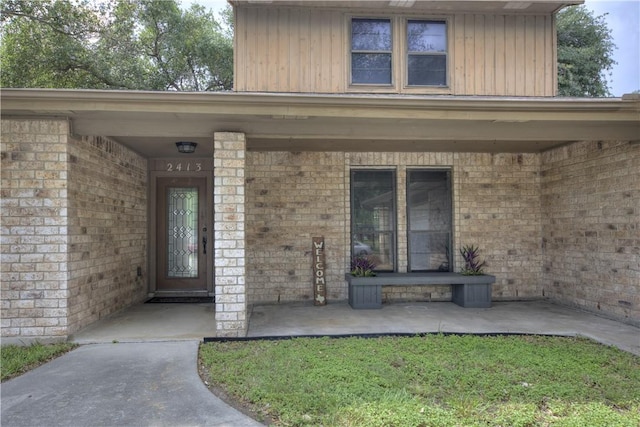 2413 Cricket Hollow St, Corpus Christi, TX 78414 - doorway to property featuring brick siding and board and batten siding