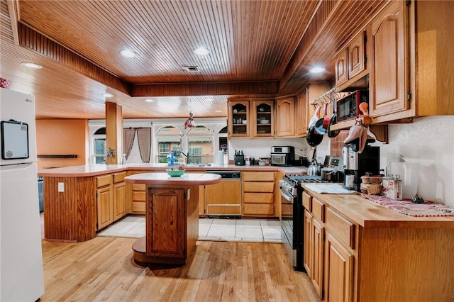 kitchen featuring wooden ceiling, freestanding refrigerator, a peninsula, stainless steel range with gas cooktop, and paneled dishwasher