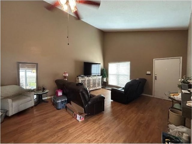 living room with high vaulted ceiling, a ceiling fan, and wood finished floors