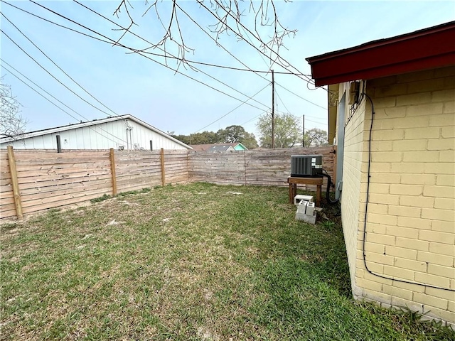 view of yard with central AC unit and a fenced backyard