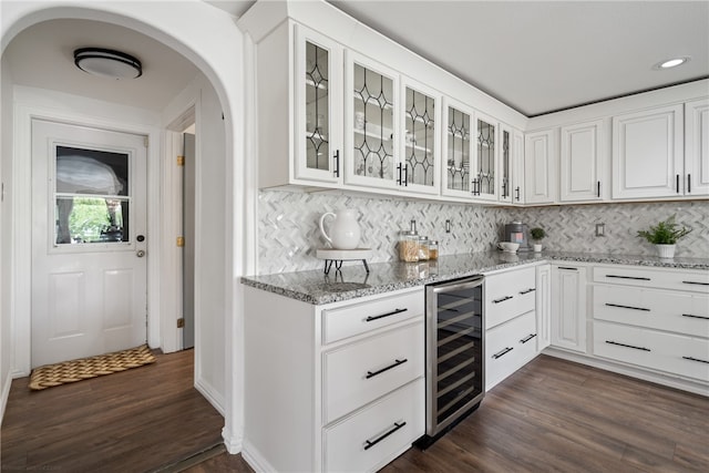 kitchen with dark hardwood / wood-style flooring, light stone counters, backsplash, white cabinetry, and wine cooler