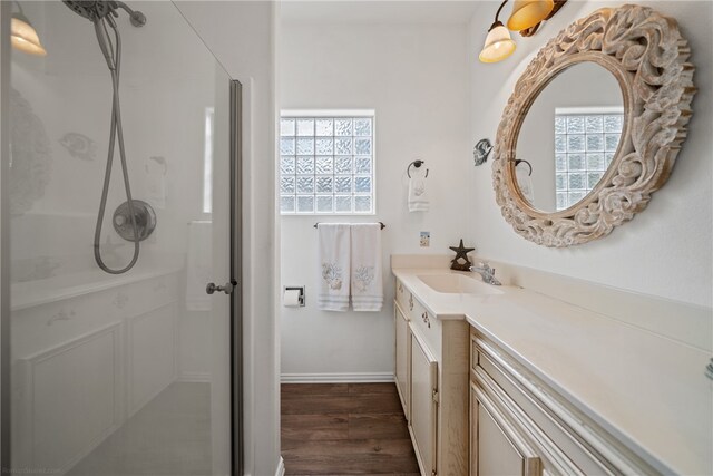 bathroom with hardwood / wood-style flooring, vanity, and walk in shower